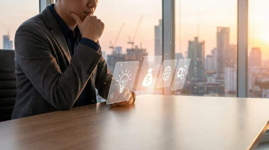 Man contemplating entrepreneurial ideas (lightbulb, money, globe, gear) at a modern desk with a city skyline at dawn.