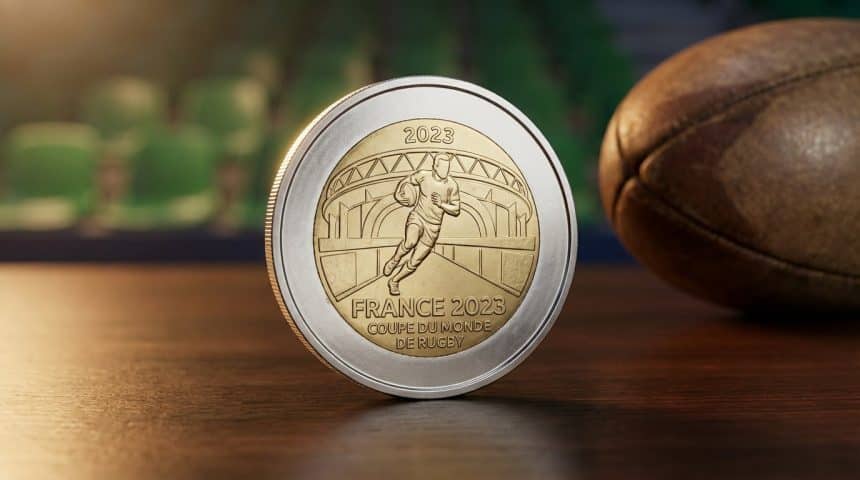 French Rugby World Cup 2023 2 euro coin, featuring a rugby player and stadium, against a blurred rugby field and ball. Metallic, detailed.