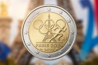 Detailed 2 euro coin for Paris 2024 Olympics, with Eiffel Tower, Olympic rings, athlete, and "PARIS 2024". Blurred background.