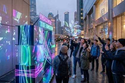 Groupe de personnes observant une installation artistique lumineuse et interactive dans une ville moderne.
