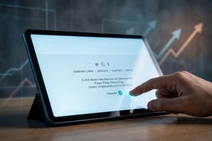 Main touchant l'écran d'une tablette affichant un footer de site web avec des liens et un bouton d'abonnement.